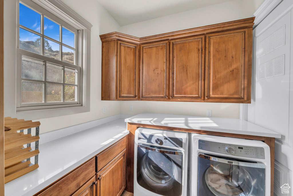 Laundry room with washer and clothes dryer and cabinet space
