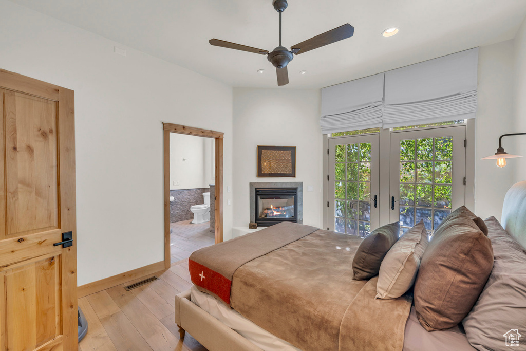 Bedroom with visible vents, access to exterior, light wood-type flooring, a glass covered fireplace, and recessed lighting