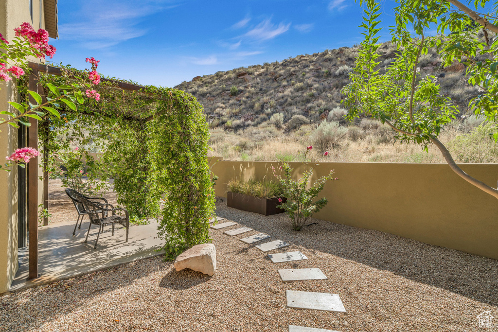 View of yard featuring a patio, a mountain view, and fence