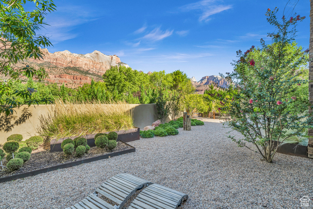 View of yard with fence, a mountain view, and a patio