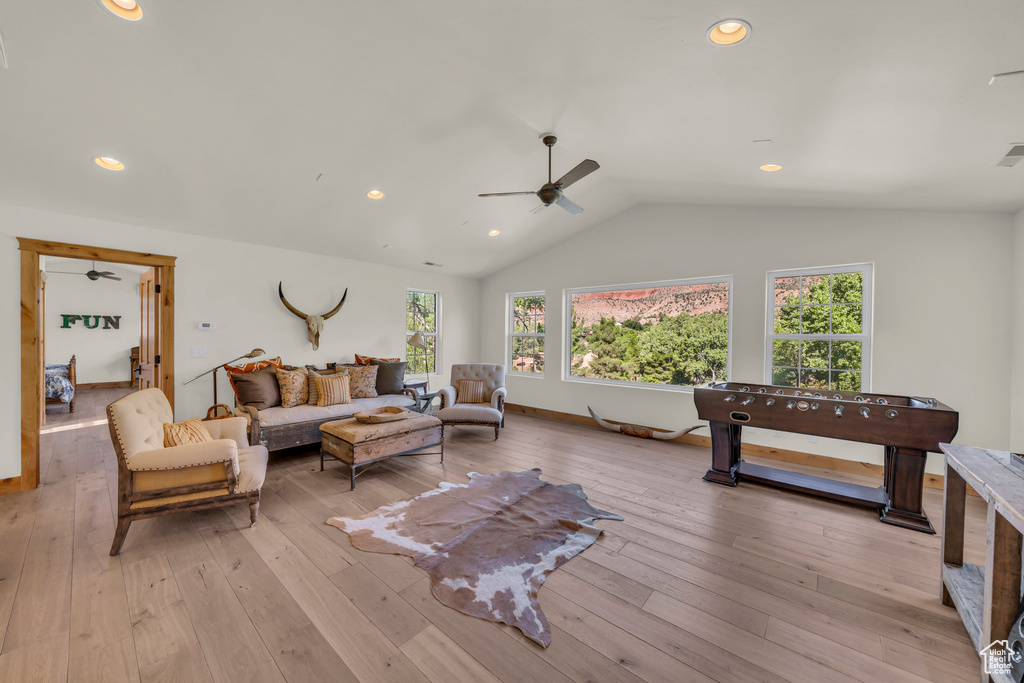 Living area featuring plenty of natural light, light wood-style flooring, ceiling fan, and lofted ceiling