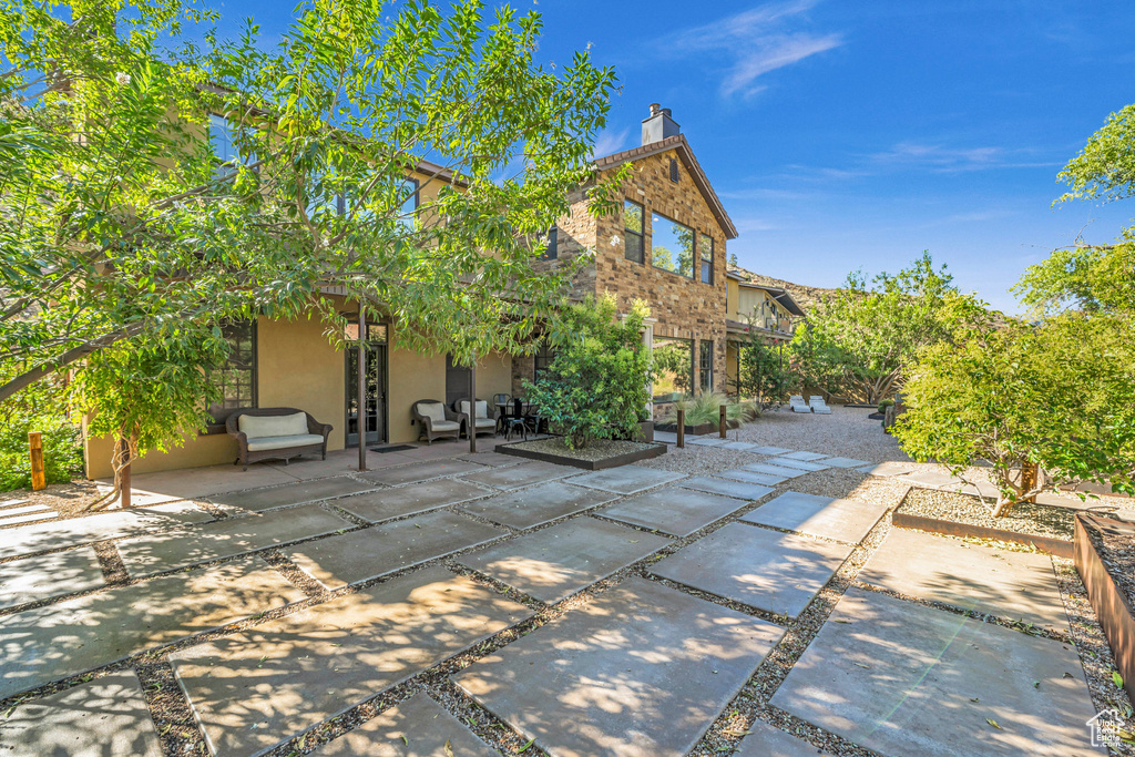 Exterior space with french doors, a chimney, a patio, outdoor lounge area, and stucco siding