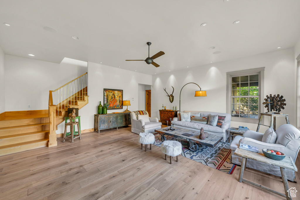 Living area featuring recessed lighting, a ceiling fan, hardwood / wood-style flooring, and stairs