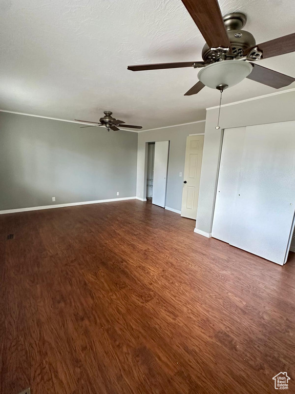 Interior space featuring baseboards, ceiling fan, and dark wood-type flooring