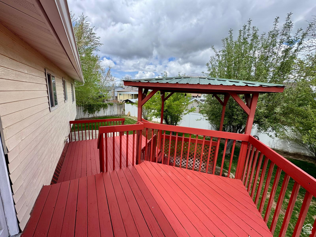 Wooden deck featuring a gazebo and a fenced backyard