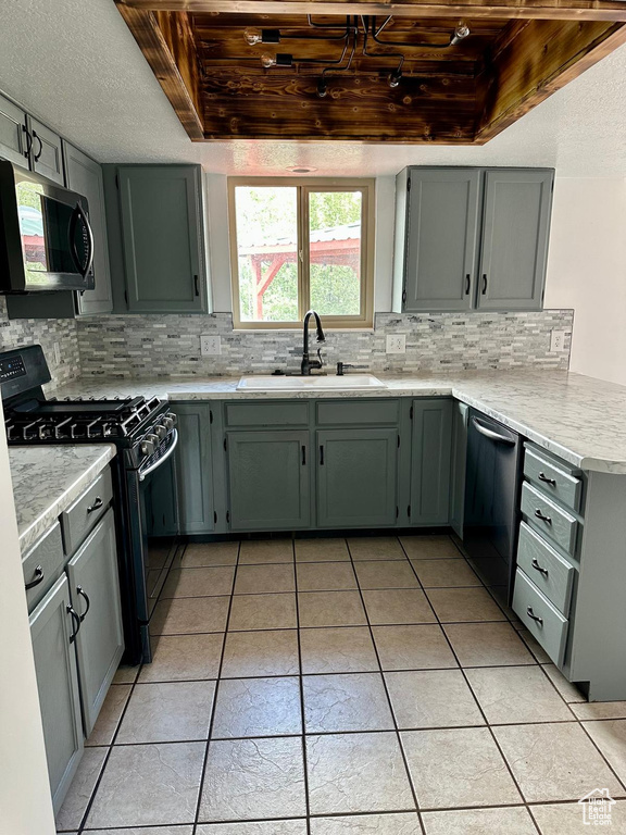 Kitchen with a sink, appliances with stainless steel finishes, backsplash, and light tile patterned flooring