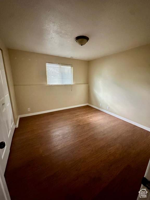 Empty room featuring baseboards and wood finished floors