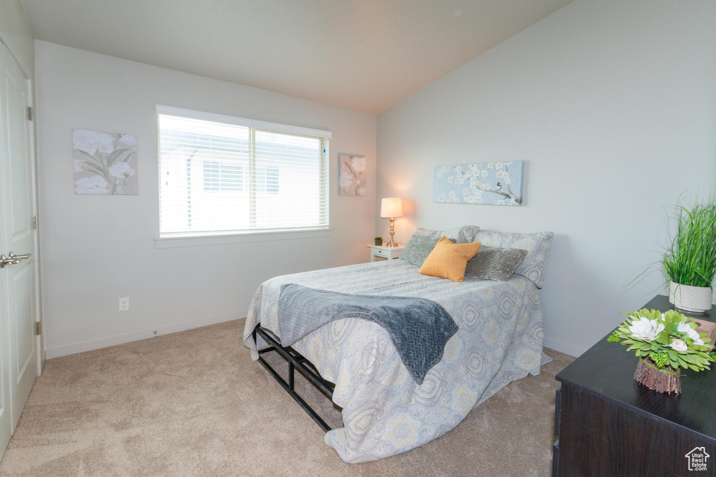Bedroom featuring baseboards, carpet flooring, and lofted ceiling