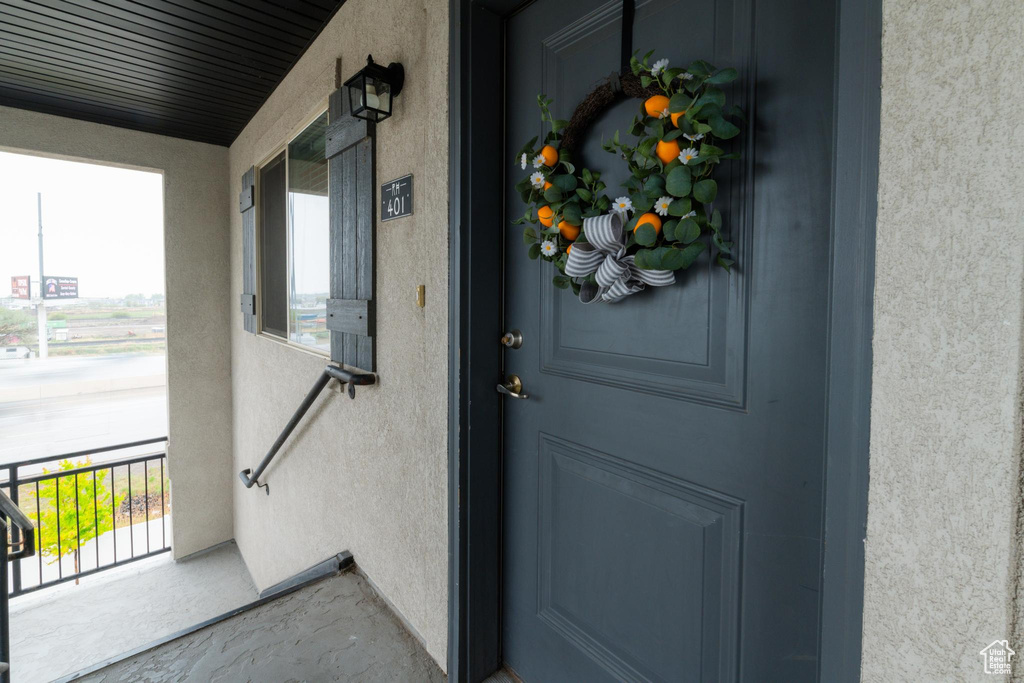 Doorway to property featuring stucco siding and covered porch