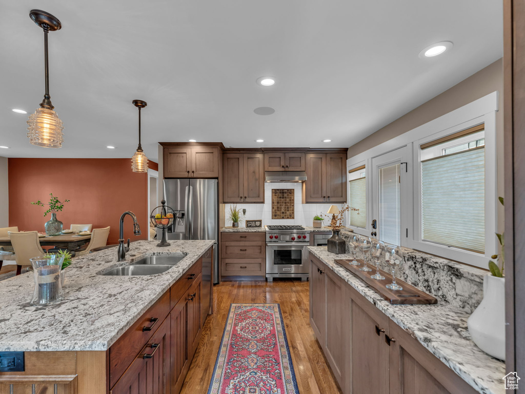 Kitchen with stainless steel appliances, recessed lighting, a sink, and light wood-style floors