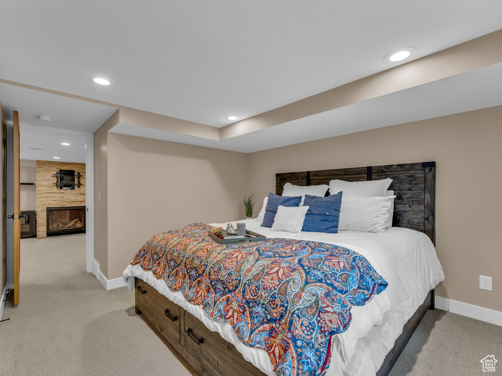 Bedroom featuring baseboards, light carpet, recessed lighting, and a large fireplace