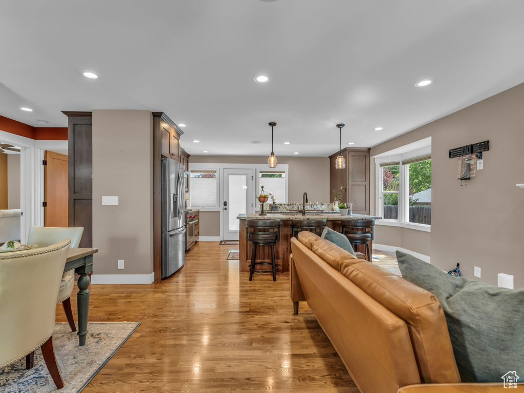 Living room featuring baseboards, light wood finished floors, and recessed lighting