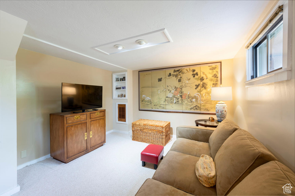 Living area featuring baseboards and light colored carpet