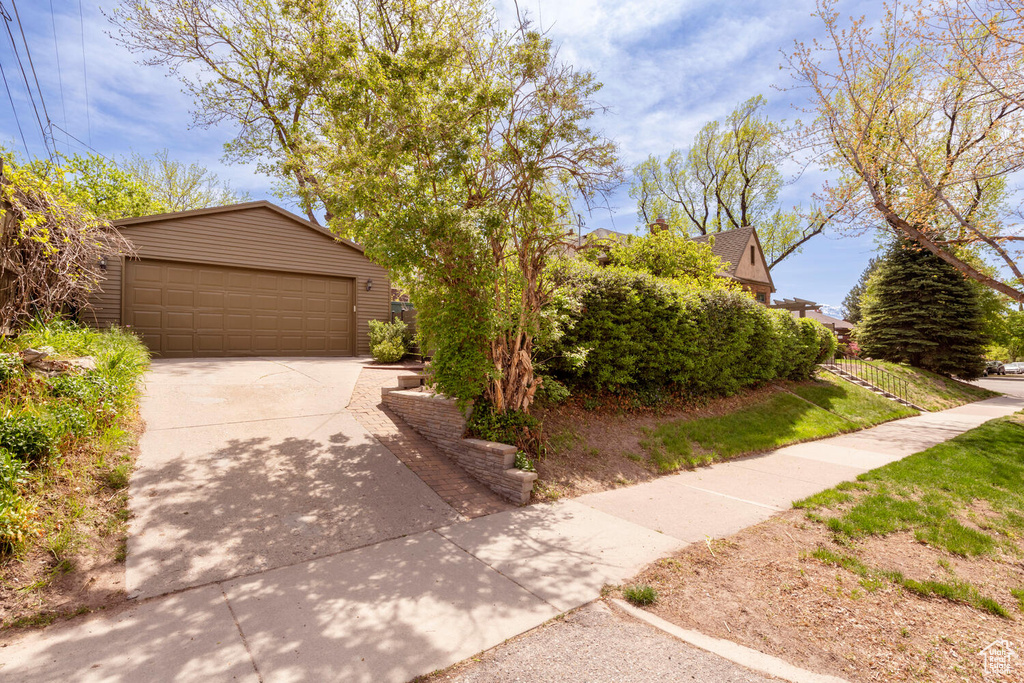 View of front of property featuring a garage, an outbuilding, and concrete driveway