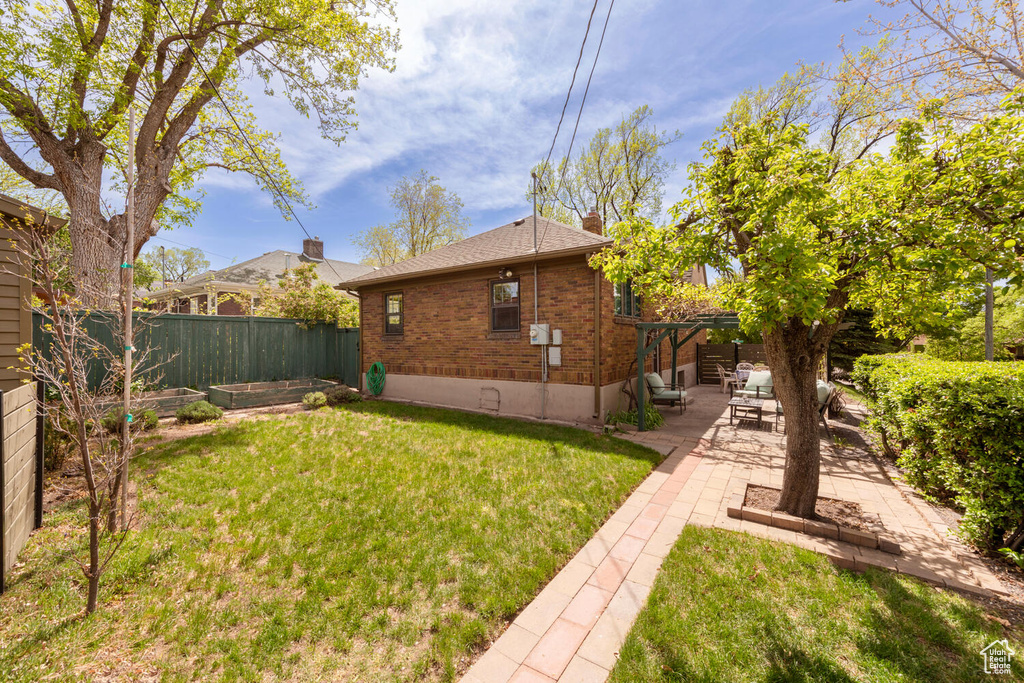 View of yard featuring fence, a patio area, and a vegetable garden
