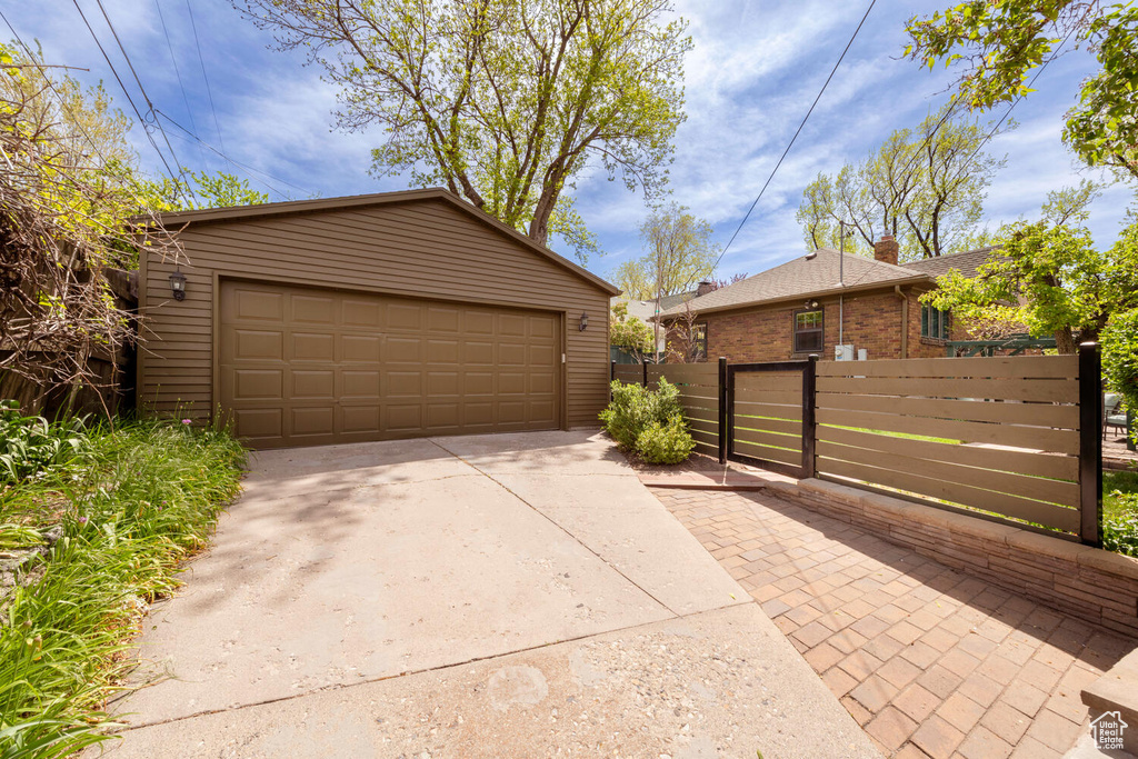 Garage featuring fence and concrete driveway