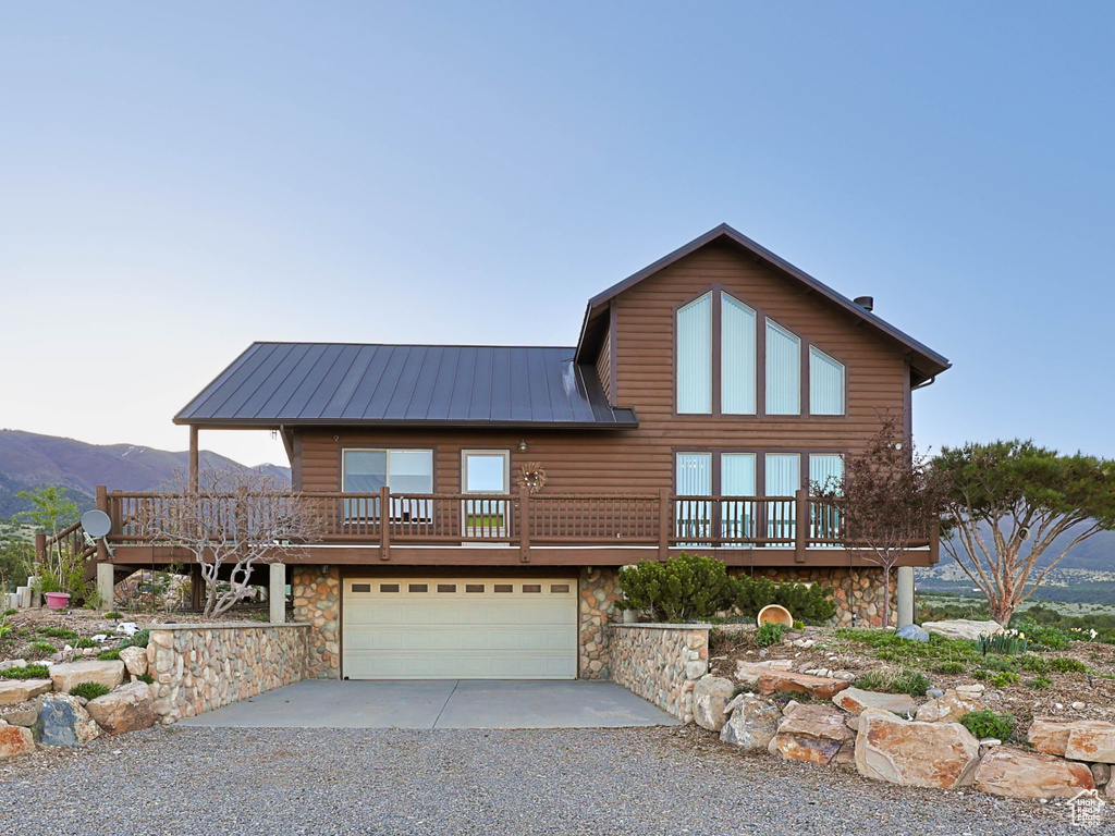 Contemporary home with a garage, a mountain view, driveway, and stone siding