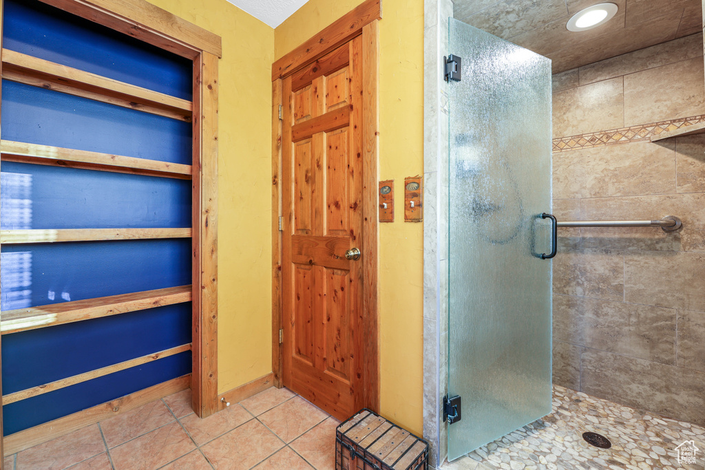 Bathroom featuring tile patterned floors and a stall shower