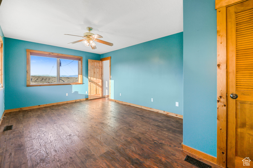 Unfurnished bedroom featuring visible vents, a ceiling fan, baseboards, and wood finished floors