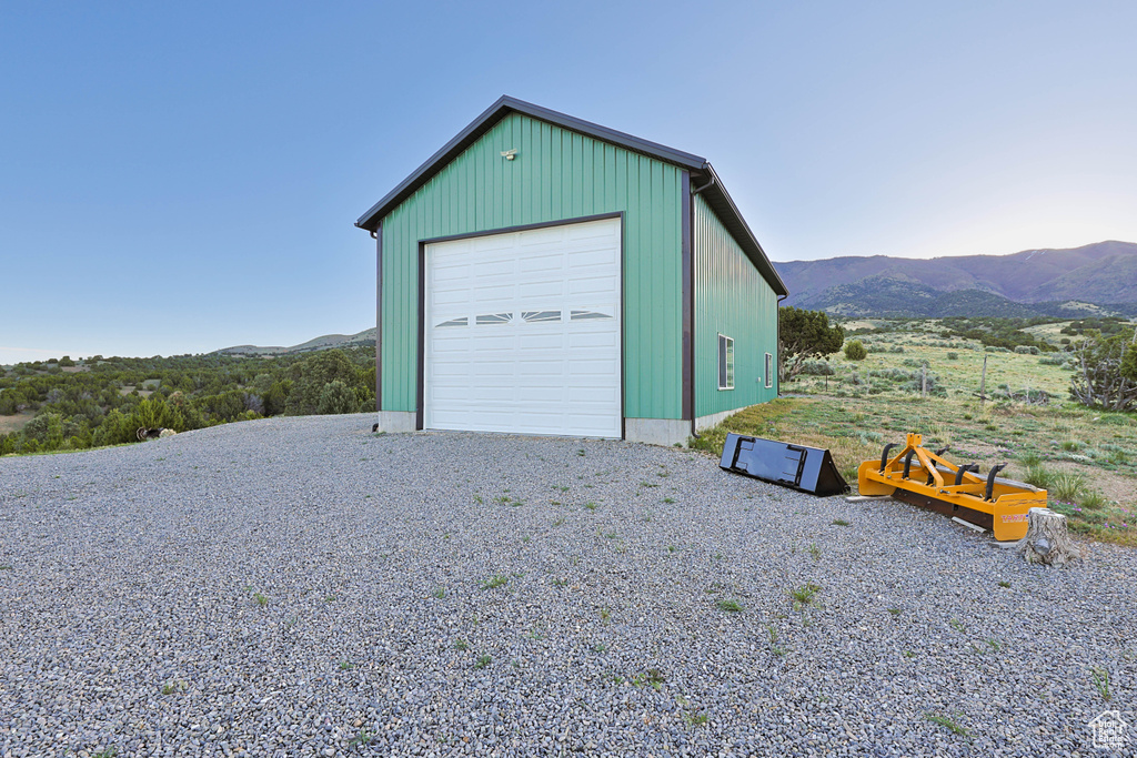 Detached garage with a mountain view and gravel driveway