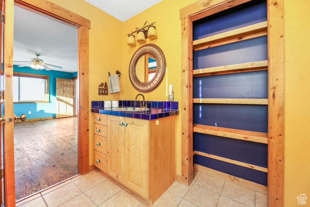 Bathroom with vanity, ceiling fan, and tile patterned floors