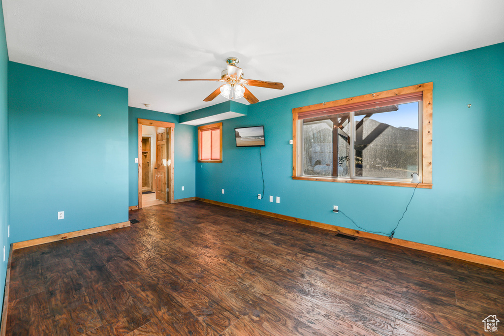 Spare room with baseboards, a ceiling fan, and wood finished floors