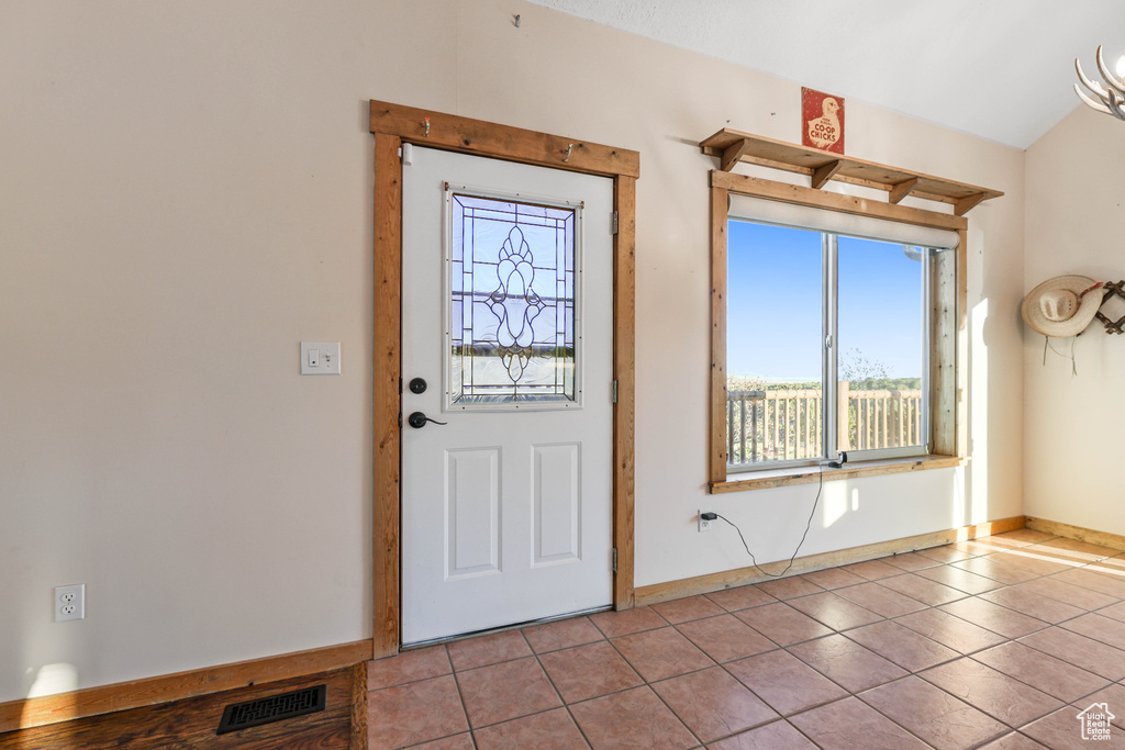 Tiled foyer with baseboards and visible vents