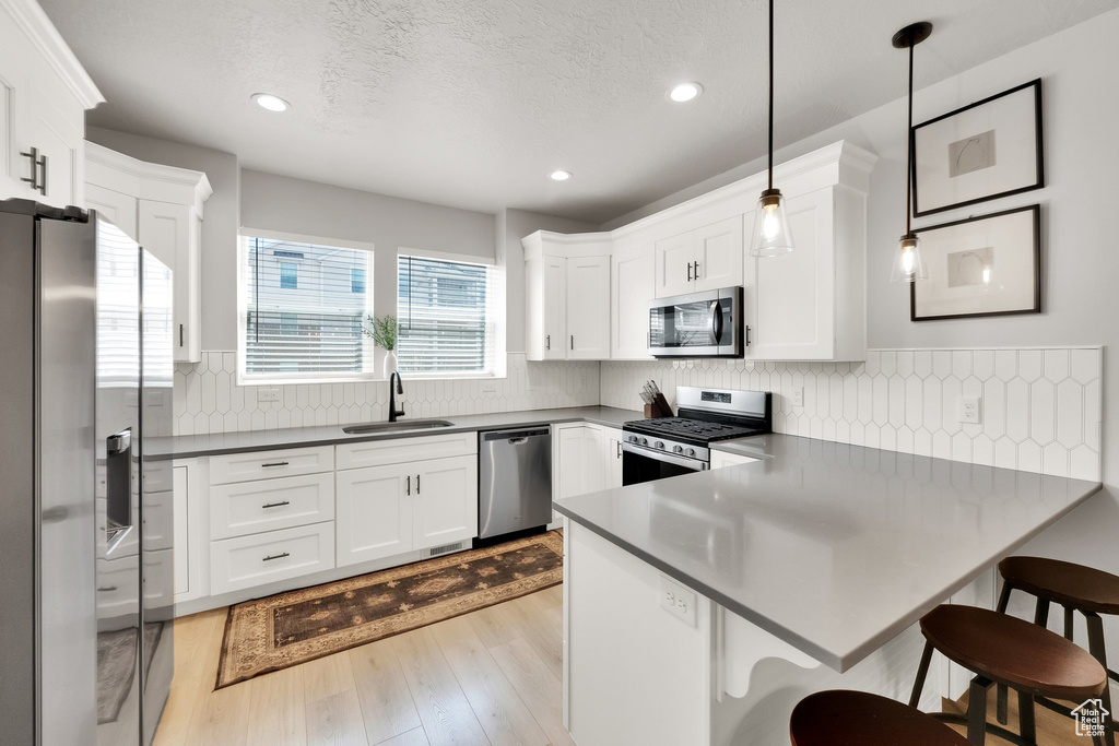 Kitchen with recessed lighting, a sink, a peninsula, and stainless steel appliances