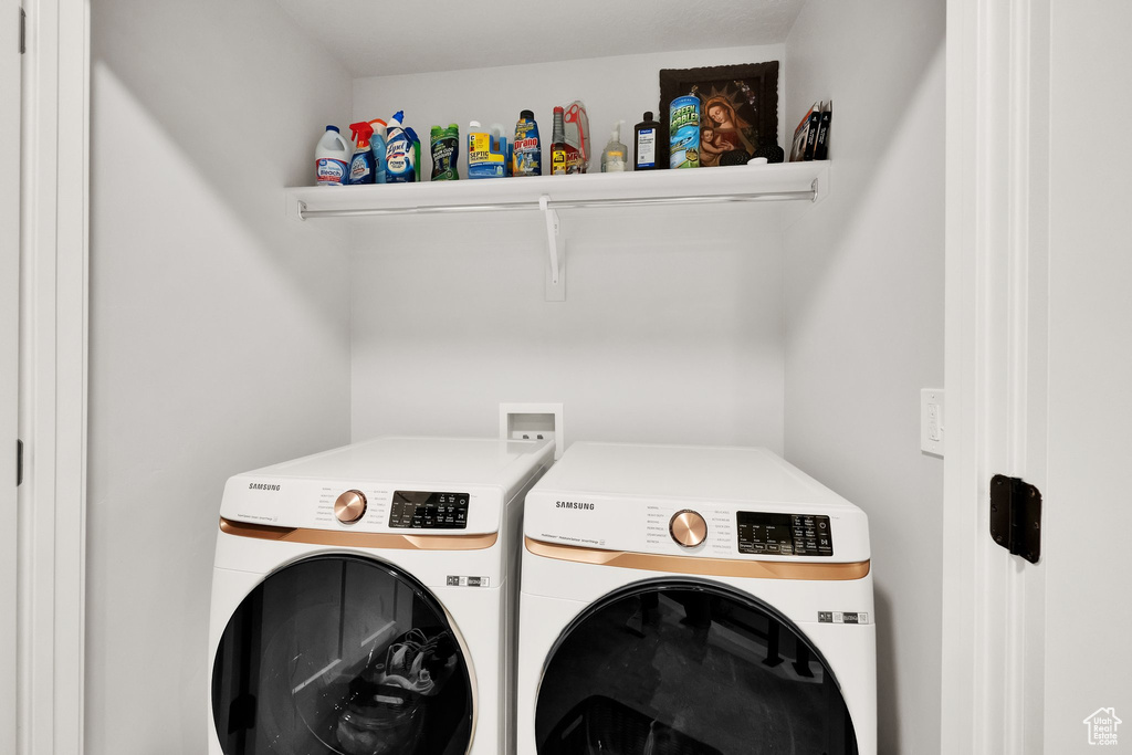 Clothes washing area featuring washing machine and clothes dryer and laundry area