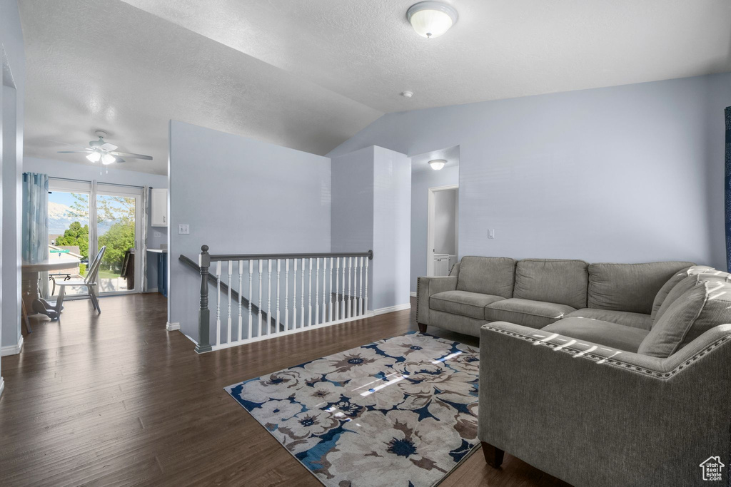 Living room featuring baseboards, a ceiling fan, wood finished floors, and lofted ceiling