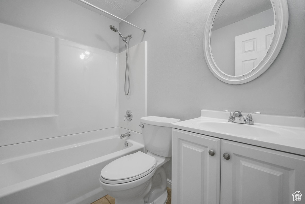 Bathroom featuring vanity, tile patterned flooring, shower / bathtub combination, and toilet