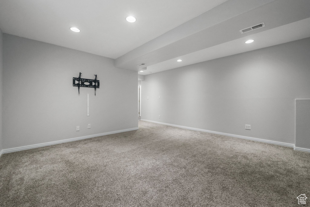 Carpeted spare room featuring baseboards, recessed lighting, and visible vents