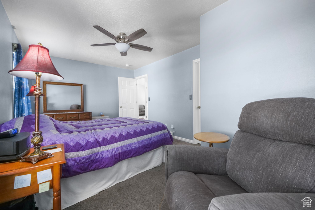 Carpeted bedroom with baseboards and a ceiling fan
