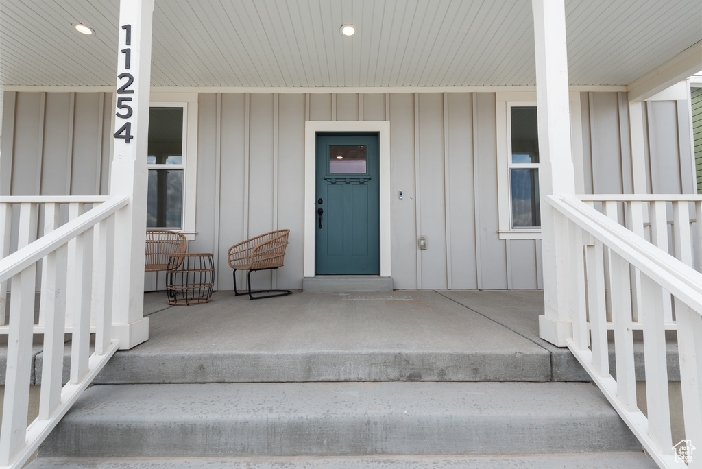 Entrance to property with covered porch and board and batten siding