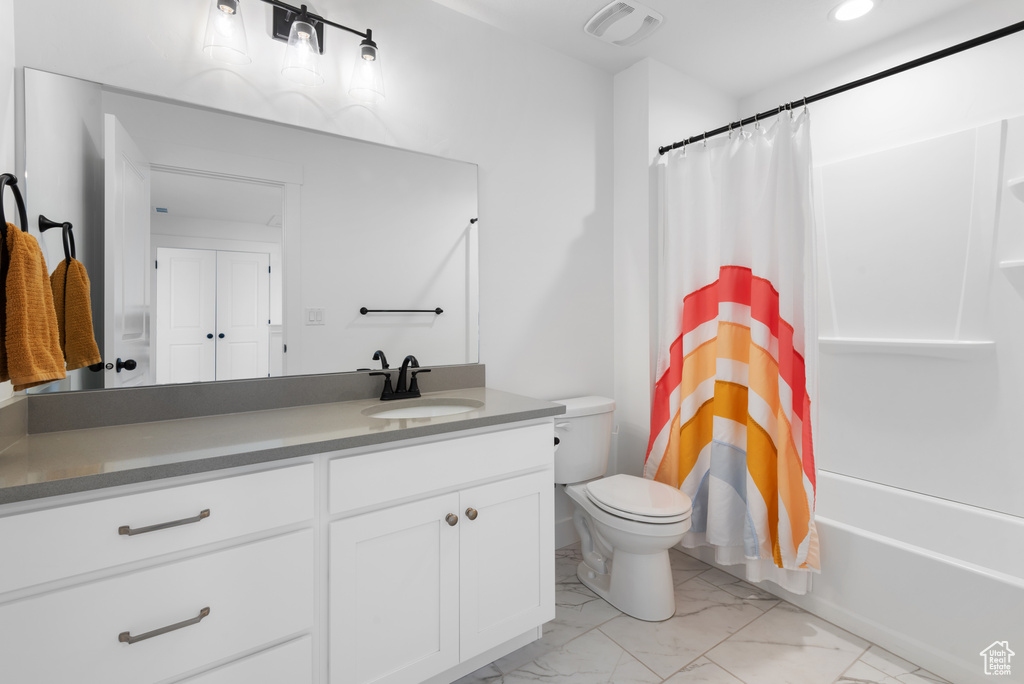Bathroom featuring vanity, shower / tub combo with curtain, marble finish floor, visible vents, and toilet