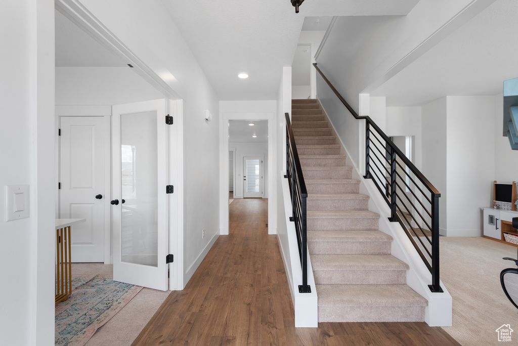 Stairway featuring recessed lighting, baseboards, and wood finished floors