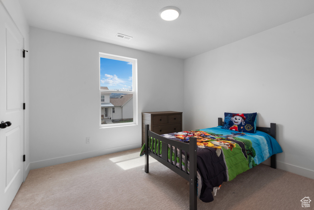 Bedroom featuring baseboards, carpet, and visible vents