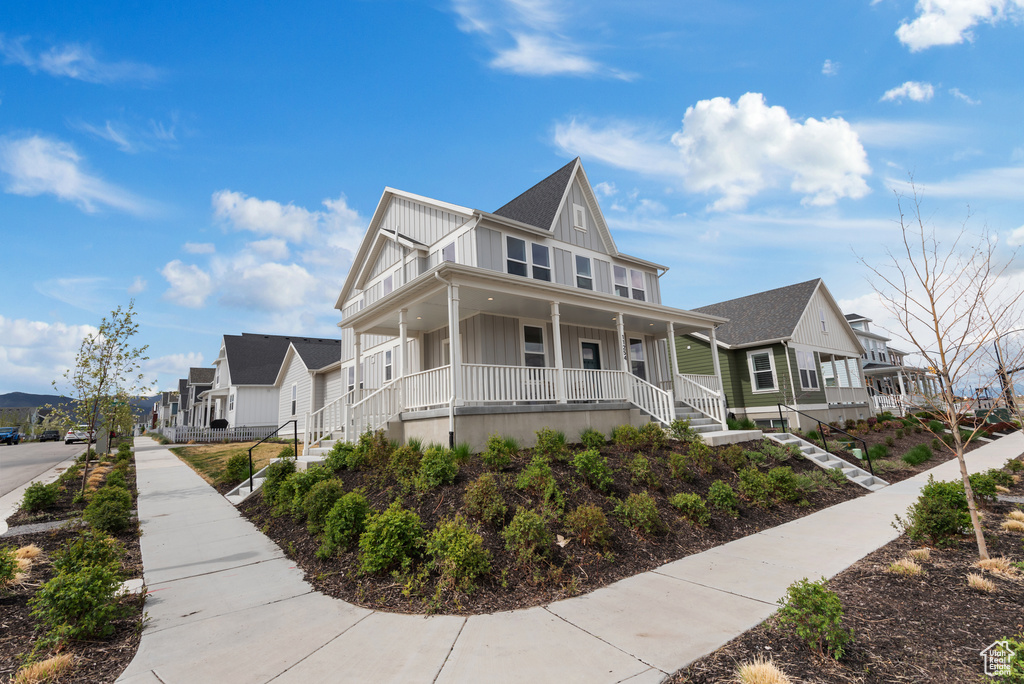 View of front of house featuring a residential view, covered porch, board and batten siding, and stairs