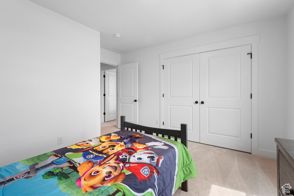 Bedroom featuring a closet and light colored carpet