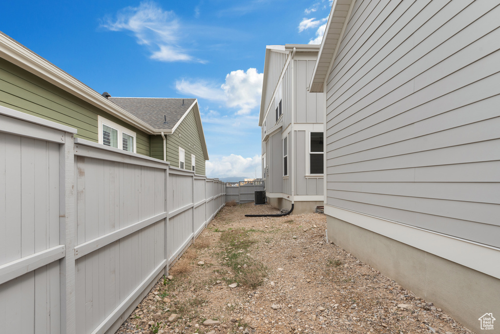 View of yard featuring central air condition unit and fence