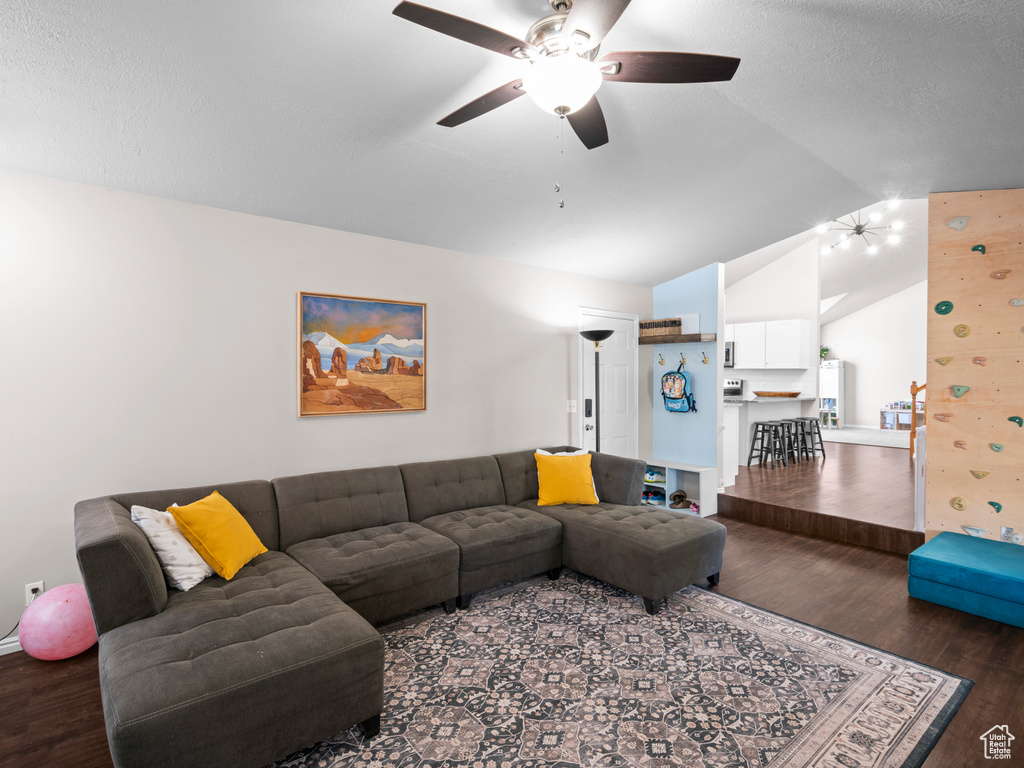 Living area featuring a ceiling fan, wood finished floors, and vaulted ceiling
