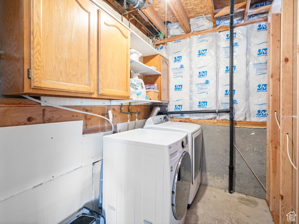 Washroom featuring cabinet space and washer and dryer