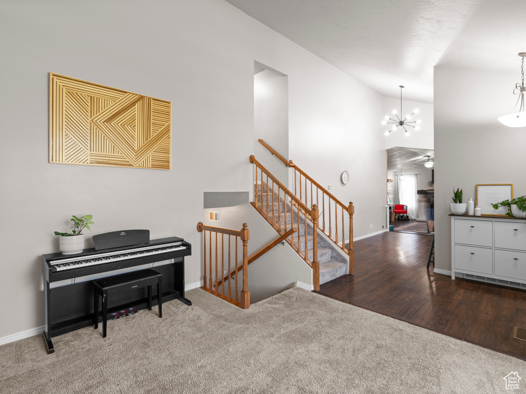 Interior space featuring an inviting chandelier, baseboards, and high vaulted ceiling