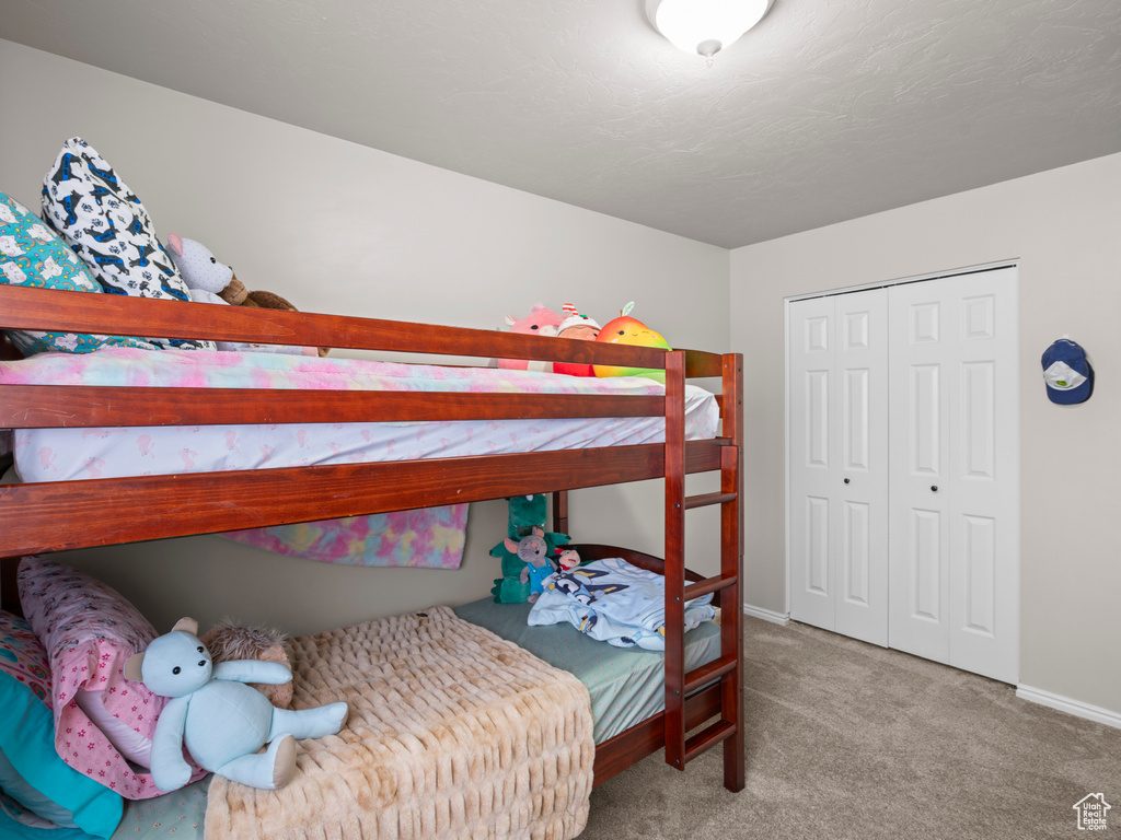 Bedroom with carpet floors, baseboards, and a closet