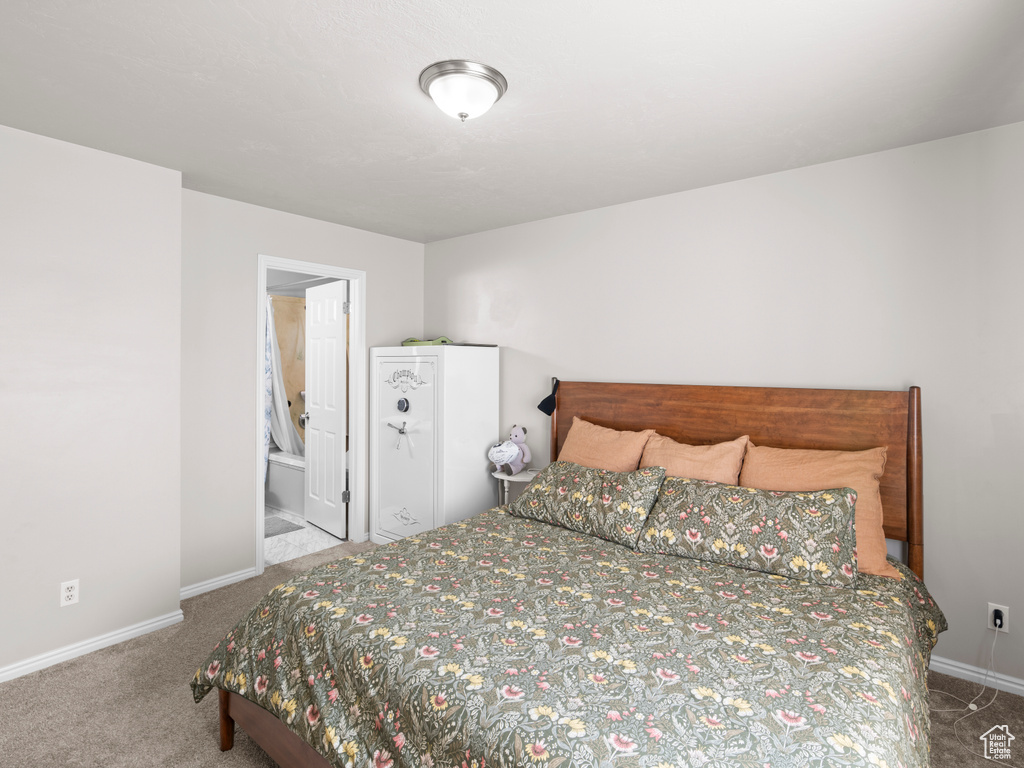 Carpeted bedroom with baseboards and ensuite bath