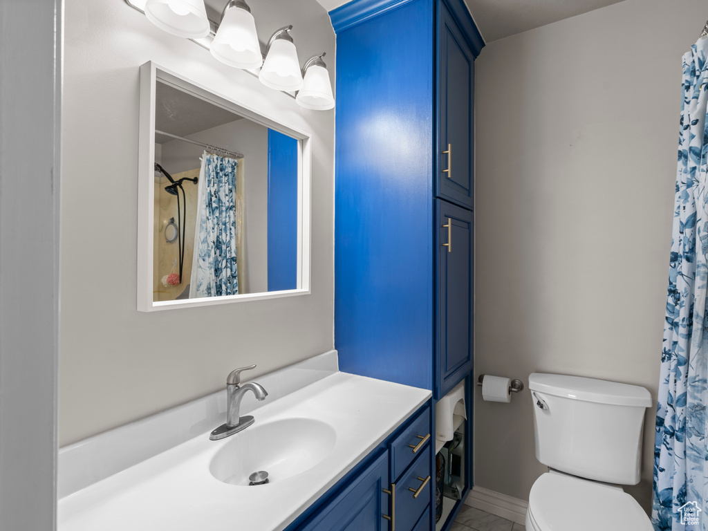 Bathroom featuring vanity, a shower with shower curtain, toilet, and marble finish floor