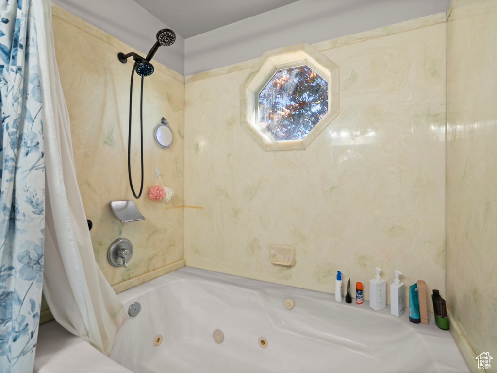 Full bath with a combined bath / shower with jetted tub