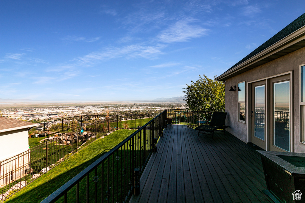 Wooden deck featuring a mountain view and a yard