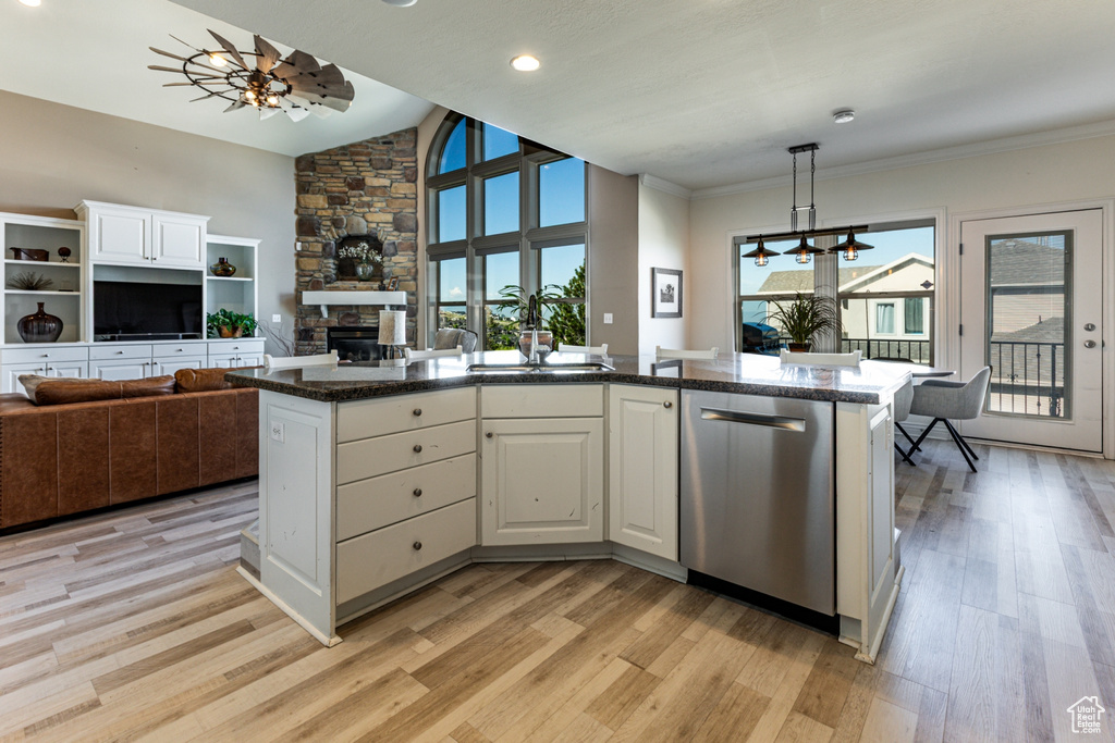 Kitchen with a fireplace, open floor plan, light wood-type flooring, and dishwasher