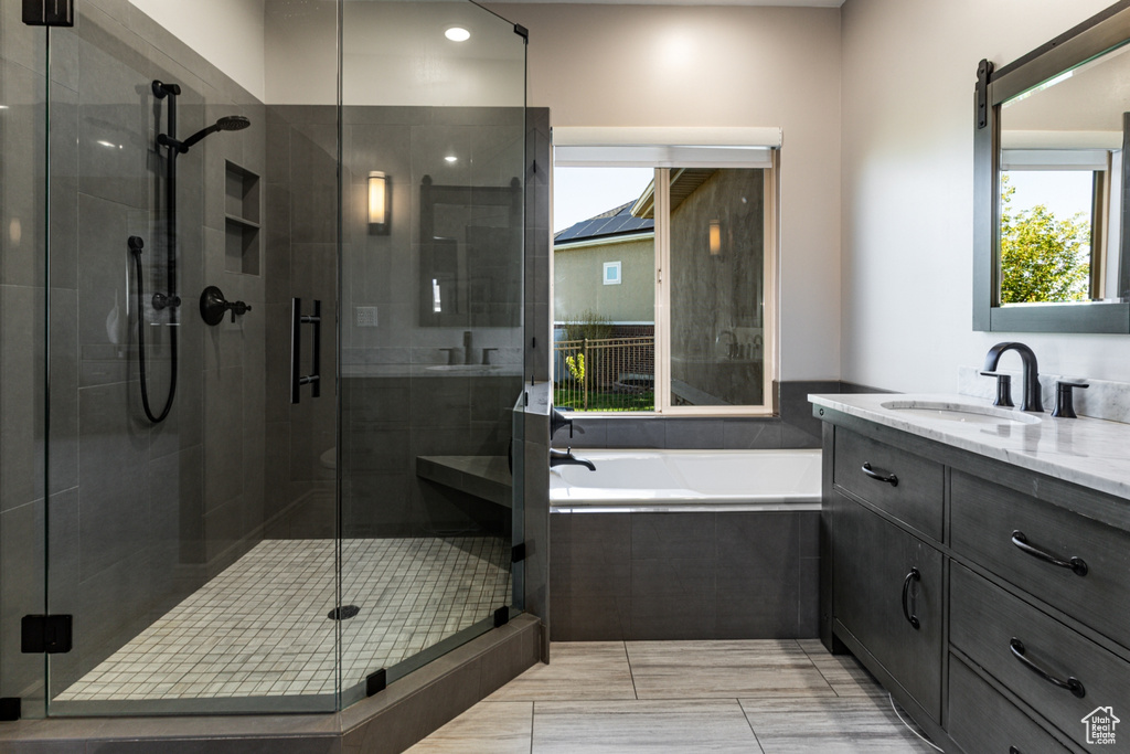 Bathroom featuring vanity, a stall shower, recessed lighting, and a bath